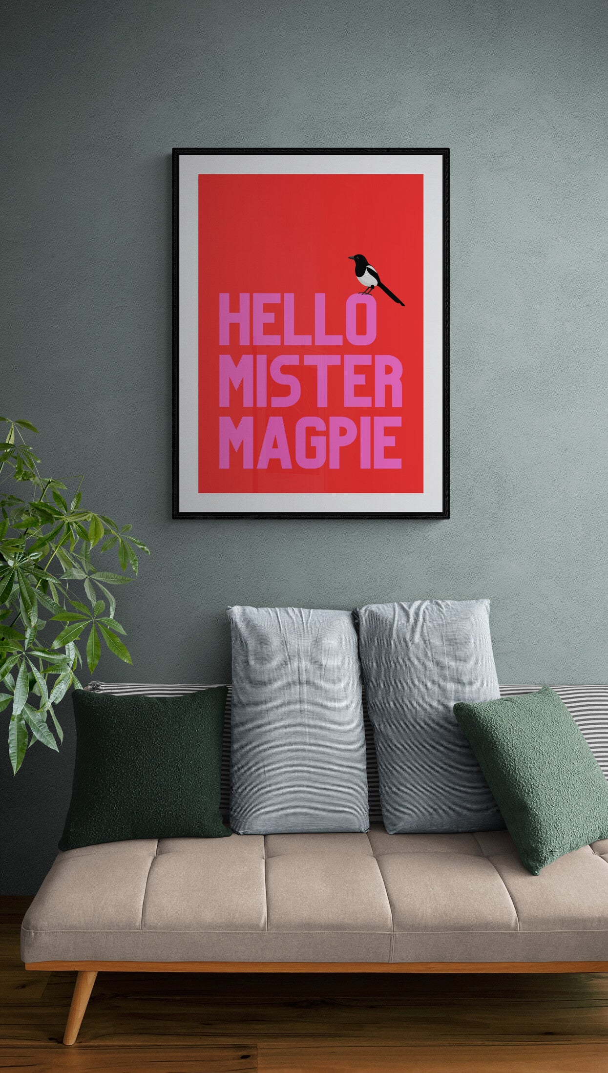 Bright bold poster with magpie sitting on the wording hello mister magpie as per the folklore saying one for sorrow two for joy framed on the wall above a sofa