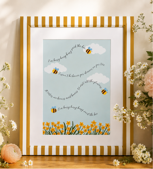 Painted framed artwork with bees and flowers on a wooden surface with floral decorations.