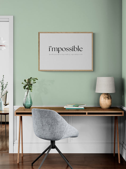 Modern home office with a green wall, desk, chair, and framed poster saying i'mpossible - if something so small can change everything, imagine what you can do.